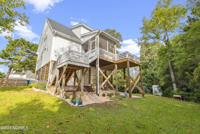 back of house with a wooden deck, a lawn, and a sunroom