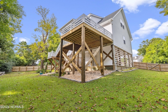 rear view of property with a lawn and a deck