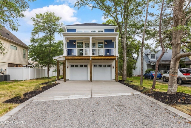 coastal inspired home featuring a garage, covered porch, and central AC