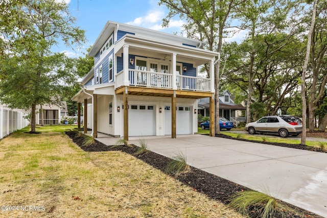 view of front of property with a front lawn, a garage, and a porch