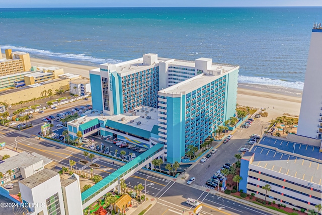 birds eye view of property with a water view and a beach view