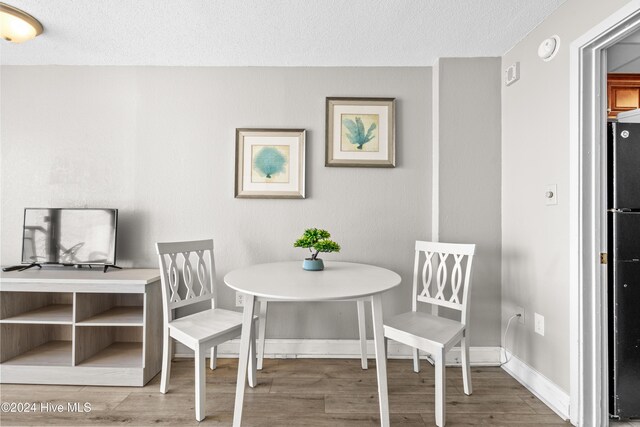 1501 S Ocean Blvd Unit 1235, Myrtle Beach, SC 29577 - dining space featuring a textured ceiling, wood finished floors, and baseboards
