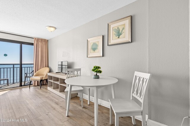 1501 S Ocean Blvd Unit 1235, Myrtle Beach, SC 29577 - living area featuring a water view, a textured ceiling, baseboards, and wood finished floors
