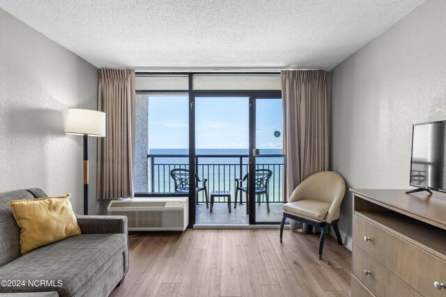 1501 S Ocean Blvd Unit 1235, Myrtle Beach, SC 29577 - living area with a textured wall, a wall of windows, wood finished floors, and a wall mounted AC
