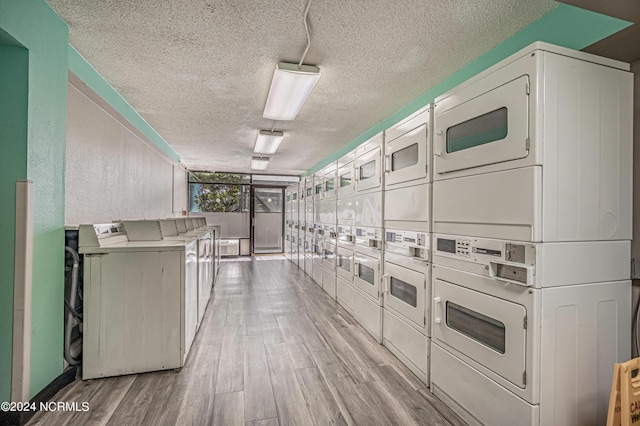 1501 S Ocean Blvd Unit 1235, Myrtle Beach, SC 29577 - community laundry room featuring stacked washer / dryer, washer and clothes dryer, a textured ceiling, and light wood finished floors
