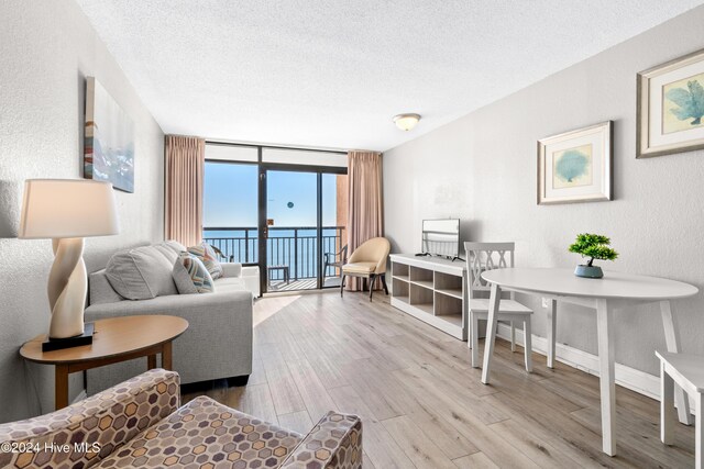1501 S Ocean Blvd Unit 1235, Myrtle Beach, SC 29577 - living area featuring baseboards, a textured wall, wood finished floors, expansive windows, and a textured ceiling