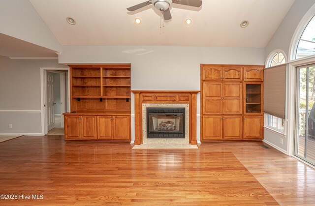 kitchen featuring stainless steel fridge, ceiling fan with notable chandelier, light hardwood / wood-style flooring, backsplash, and lofted ceiling