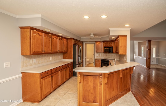 kitchen with appliances with stainless steel finishes, ceiling fan, ornamental molding, and kitchen peninsula