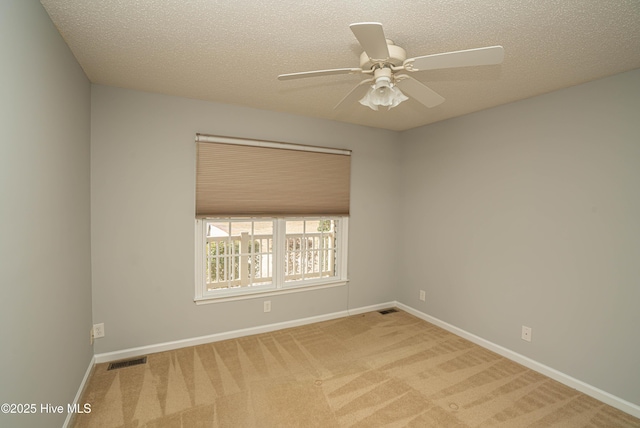 carpeted empty room with ceiling fan and a textured ceiling