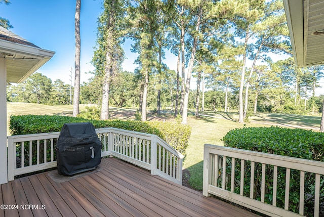 wooden terrace with a grill and a lawn