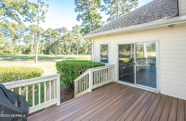 wooden deck featuring a lawn