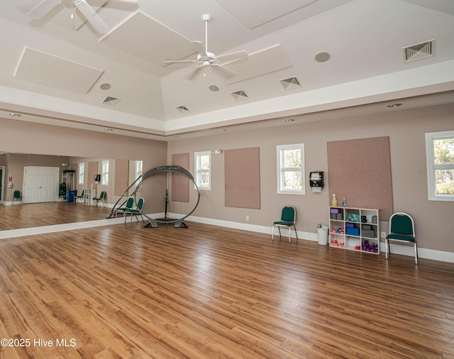 exercise area featuring hardwood / wood-style floors, lofted ceiling, ceiling fan, and plenty of natural light