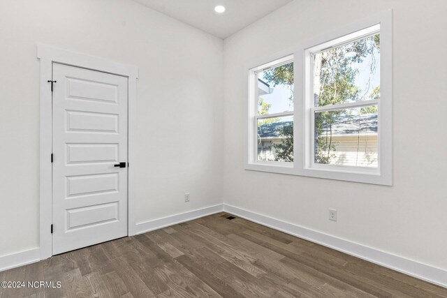 spare room with baseboards, recessed lighting, dark wood-style floors, and visible vents
