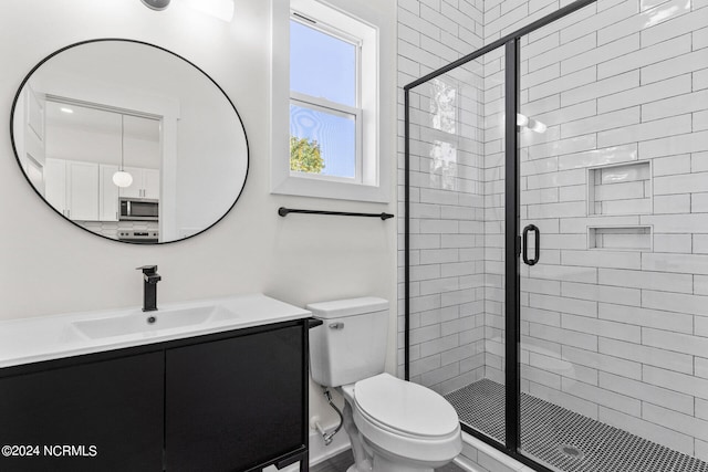 full bath featuring toilet, a shower stall, and vanity