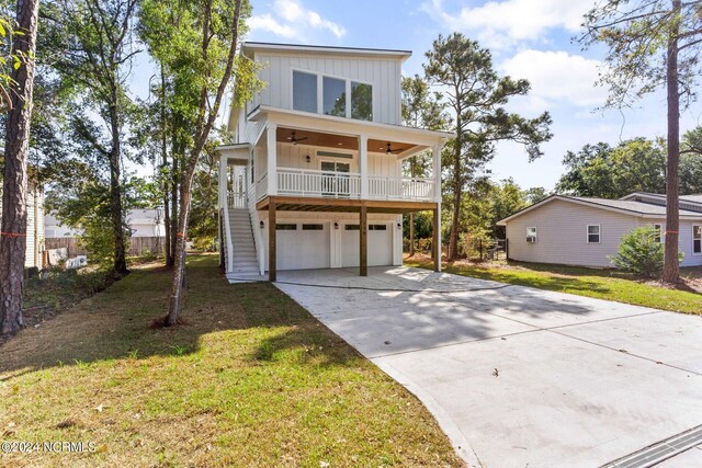 view of front of house with ceiling fan, a front lawn, and a garage