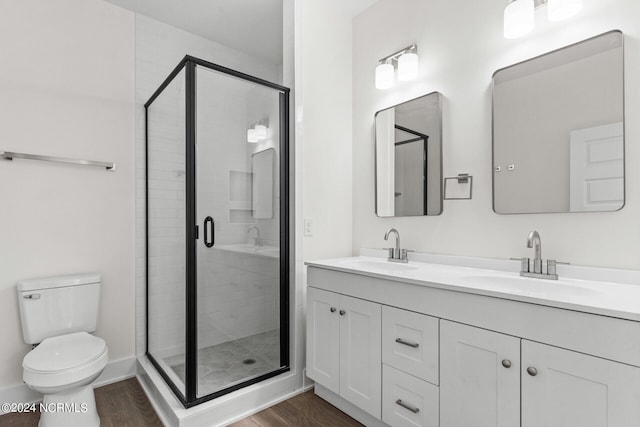bathroom featuring wood finished floors, a sink, and a stall shower
