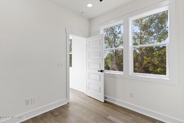 empty room featuring baseboards, recessed lighting, and wood finished floors