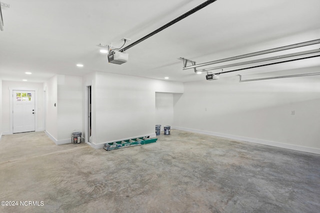 garage with baseboards, a garage door opener, and recessed lighting