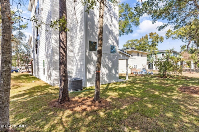 view of property exterior with a yard and central AC