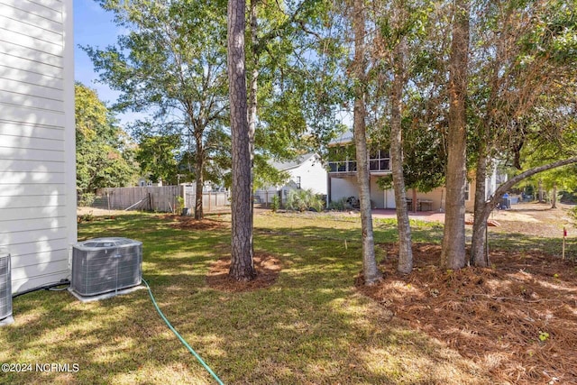 view of yard featuring central air condition unit and fence