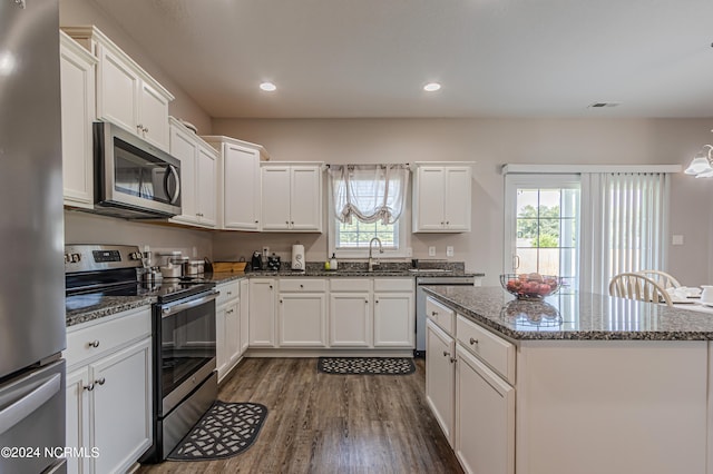 kitchen featuring white cabinets, appliances with stainless steel finishes, dark hardwood / wood-style floors, and a wealth of natural light