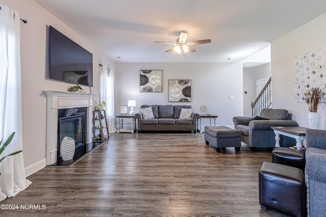 living room with ceiling fan and dark hardwood / wood-style flooring