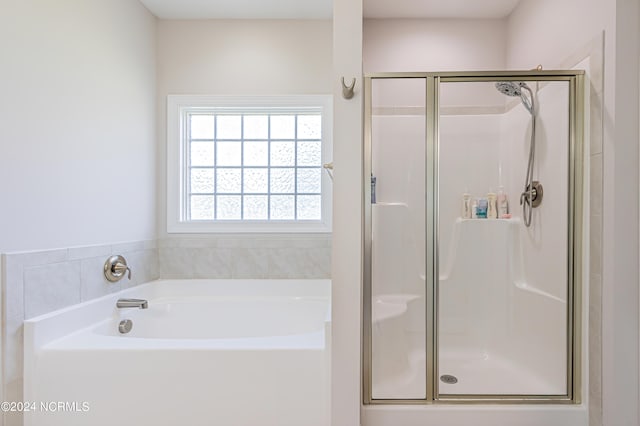 bathroom featuring shower with separate bathtub