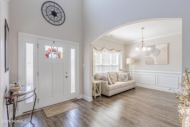 entryway with hardwood / wood-style floors, a notable chandelier, and ornamental molding