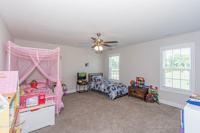 carpeted bedroom featuring ceiling fan, a textured ceiling, and multiple windows