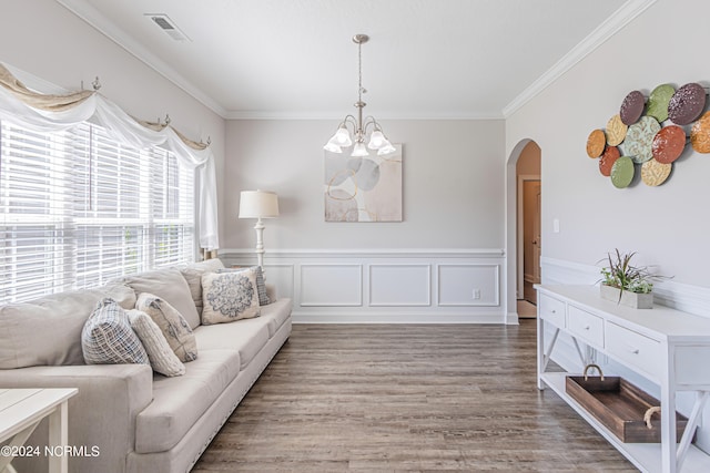 living room with hardwood / wood-style flooring, a notable chandelier, and crown molding