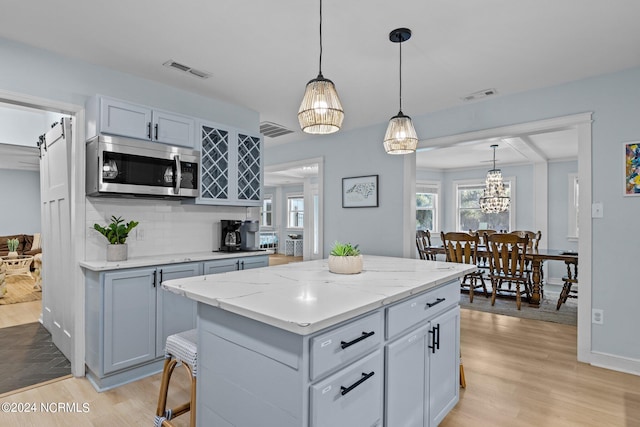 kitchen featuring light hardwood / wood-style floors, a center island, hanging light fixtures, and a breakfast bar area