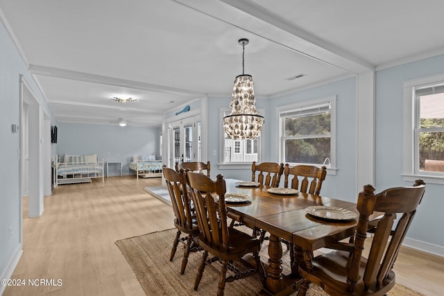 dining room with light hardwood / wood-style flooring, an inviting chandelier, and ornamental molding