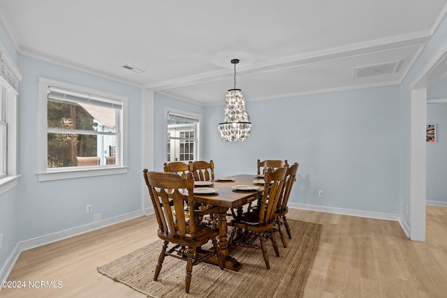 dining room featuring ornamental molding, a chandelier, and light hardwood / wood-style floors