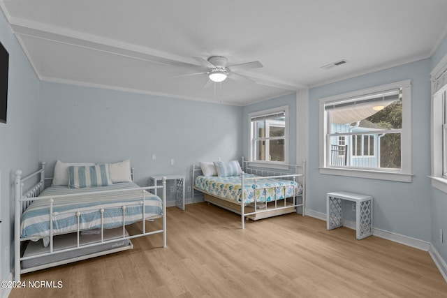 bedroom featuring crown molding, light hardwood / wood-style floors, and ceiling fan