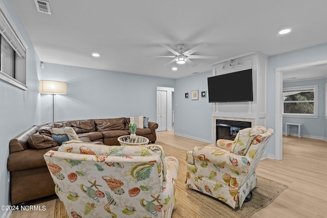 living room with ceiling fan and light hardwood / wood-style flooring