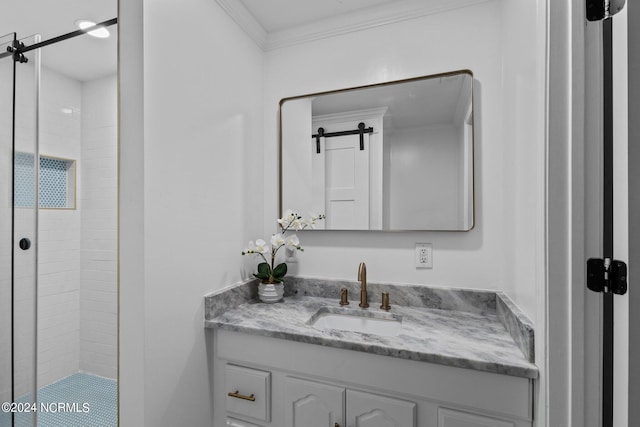 bathroom featuring ornamental molding, a tile shower, and vanity