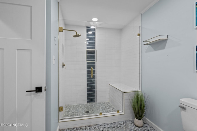 bathroom featuring tile patterned flooring, toilet, and an enclosed shower