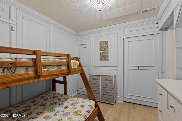 bedroom featuring light wood-type flooring, a textured ceiling, and a closet