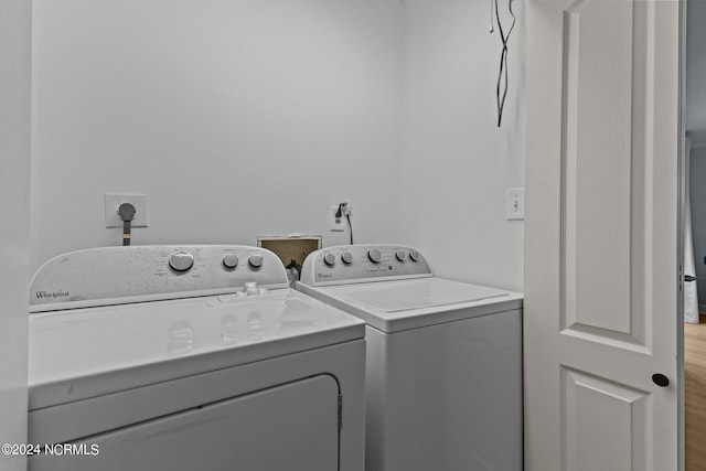 clothes washing area with wood-type flooring and washing machine and clothes dryer