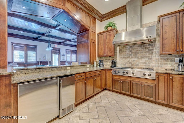 kitchen with decorative light fixtures, kitchen peninsula, stainless steel gas cooktop, and wall chimney exhaust hood