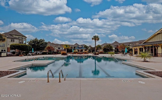 view of swimming pool with a jacuzzi and a patio area