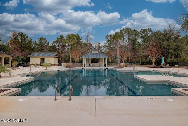 view of pool with a hot tub, a gazebo, and a patio area