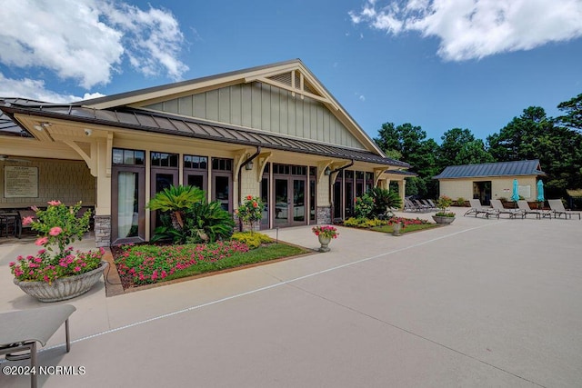 view of front of property featuring a patio, an outbuilding, and french doors