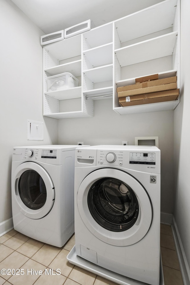 laundry area featuring independent washer and dryer and light tile patterned flooring