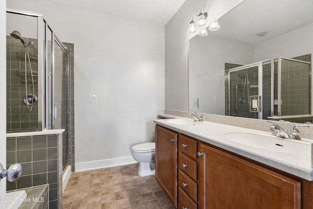 bathroom with vanity, a shower with door, and toilet