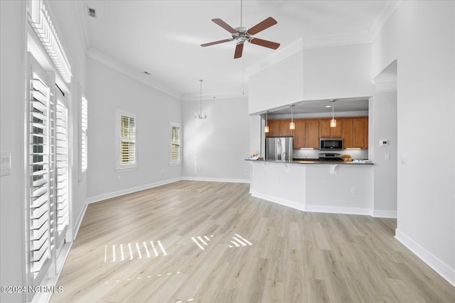 unfurnished living room with ceiling fan, ornamental molding, light hardwood / wood-style floors, and a towering ceiling