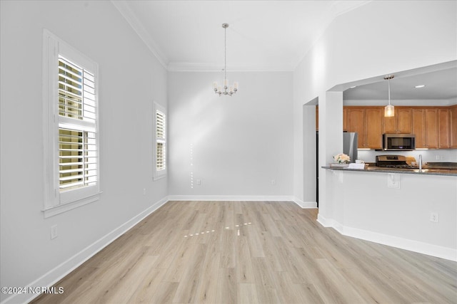 kitchen with hanging light fixtures, ornamental molding, appliances with stainless steel finishes, and light wood-type flooring