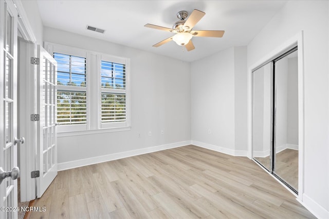 unfurnished bedroom featuring ceiling fan, light wood-type flooring, and a closet