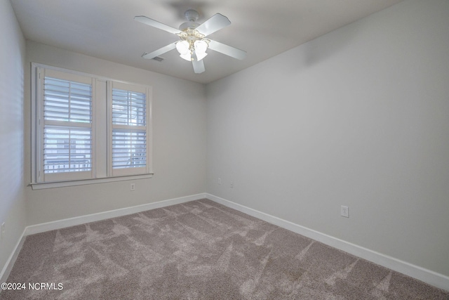 carpeted spare room featuring ceiling fan