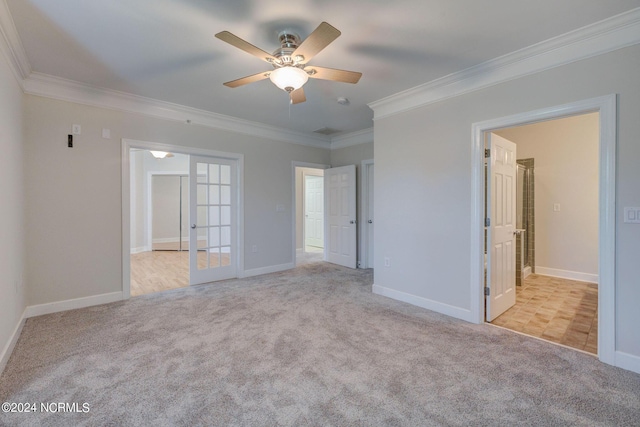 empty room with crown molding, light carpet, and french doors